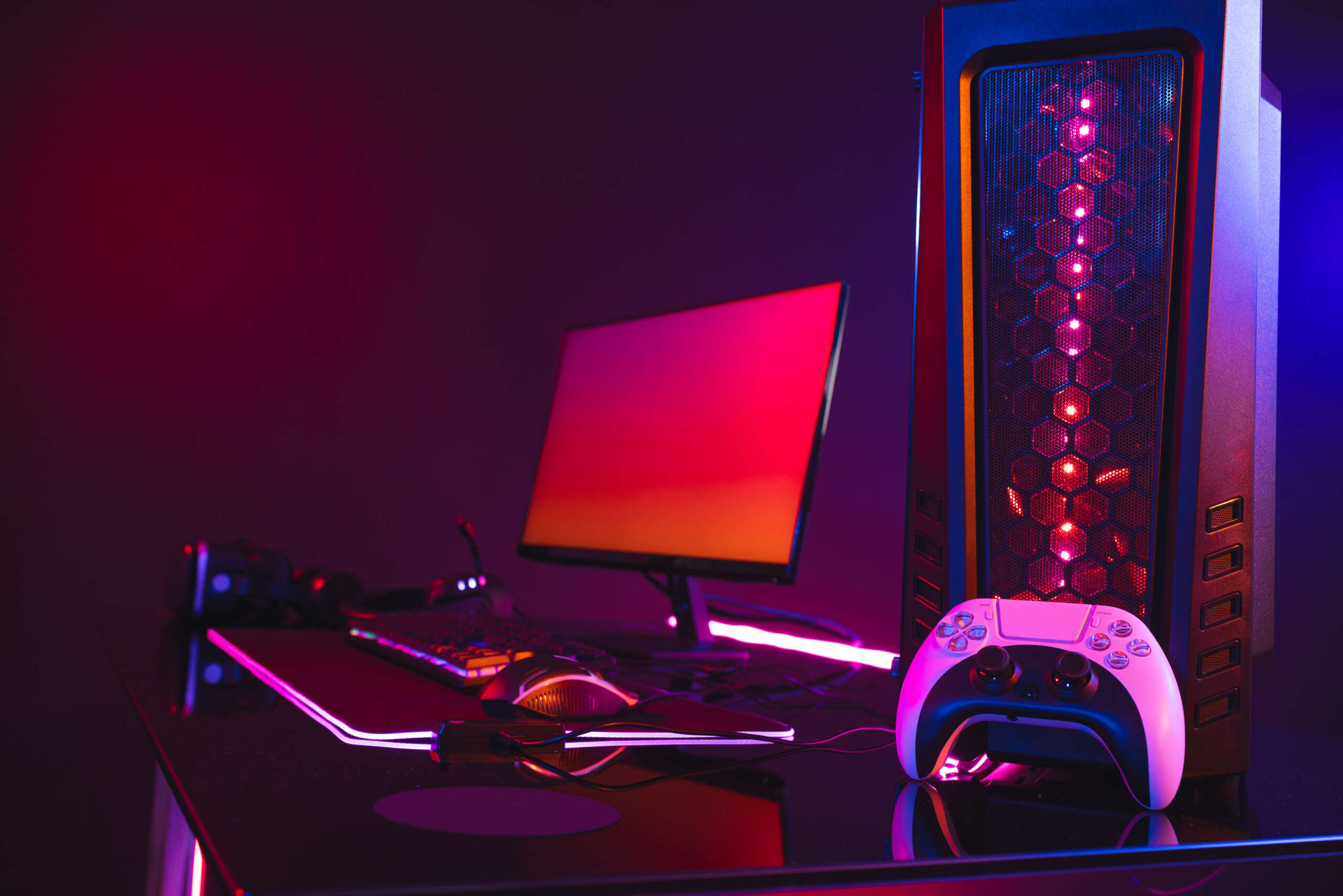 Composite of computer with video game accessories with copy space on neon background. Video game and digital connections concept digitally generated image.